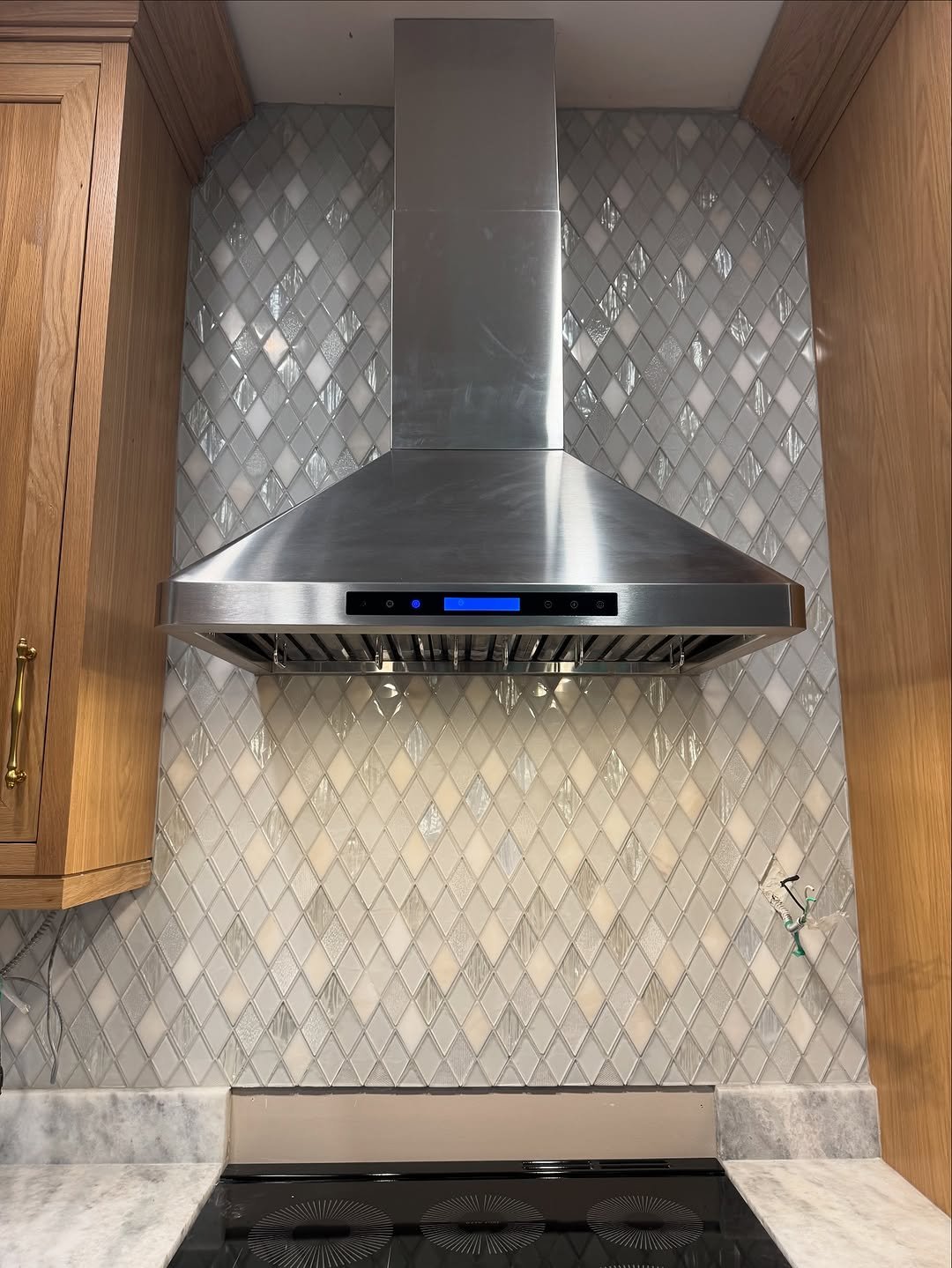 Iridescent glass diamond mosaic kitchen backsplash with stainless hood
